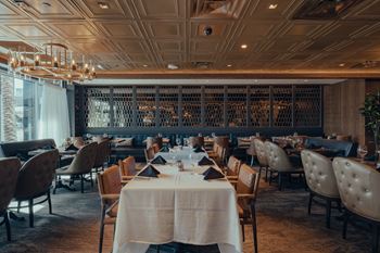 a dining room with tables and chairs and a wine cellar